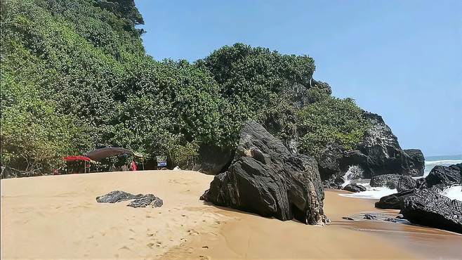 万宁山钦湾燕子洞，海边都是黑色的大石头，沙滩柔软，环境太美了