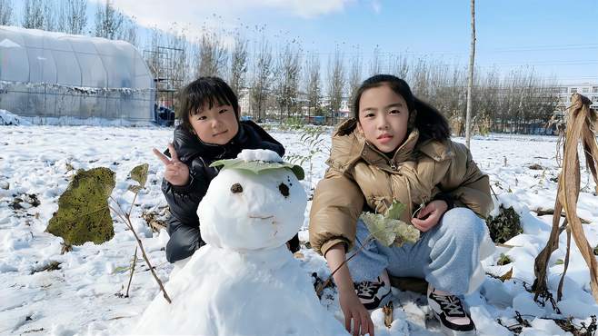 畅畅桐桐堆雪人，树叶做帽子树枝做胳膊，小手冻得通红却很开心