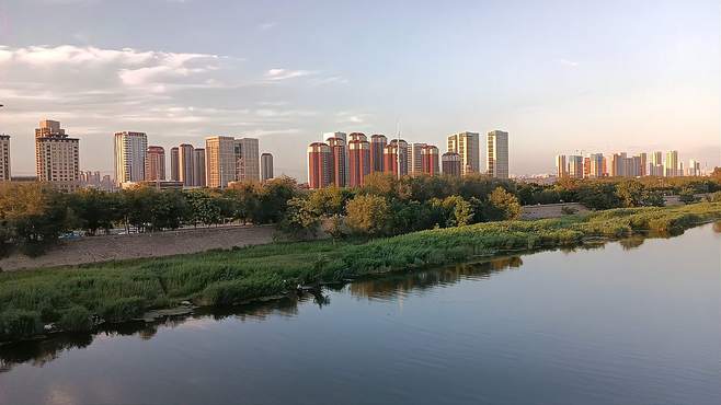 子牙河畔高楼、索桥、河面、花草树木沉浸在夕阳余晖中